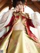 A woman in a red and gold hanfu is posing for a picture.