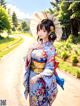 A woman in a blue kimono holding an umbrella.