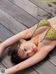 A woman in a bikini laying on a wooden deck.